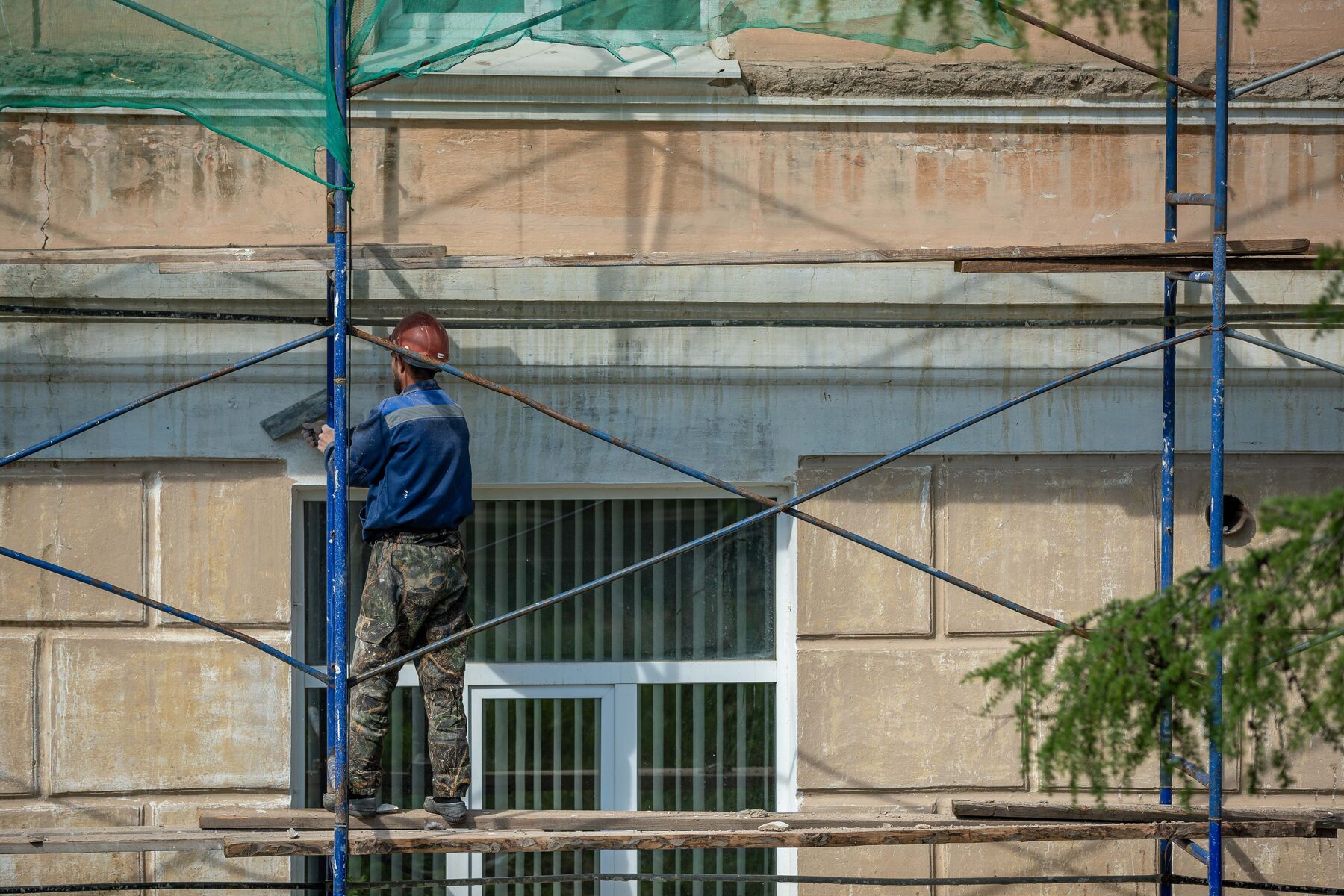 Samson technician repairing a building facade on scaffolding